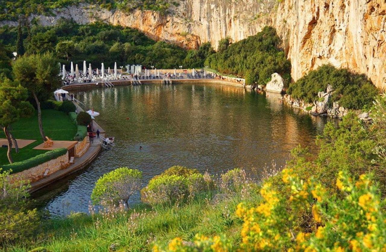 The spring-fed thermal water of Lake Vouliagmeni beneath its limestone cliff