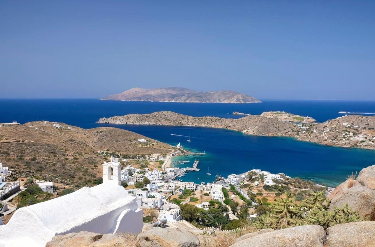 A white bell tower above Ormos harbour and the wide bay of Ios