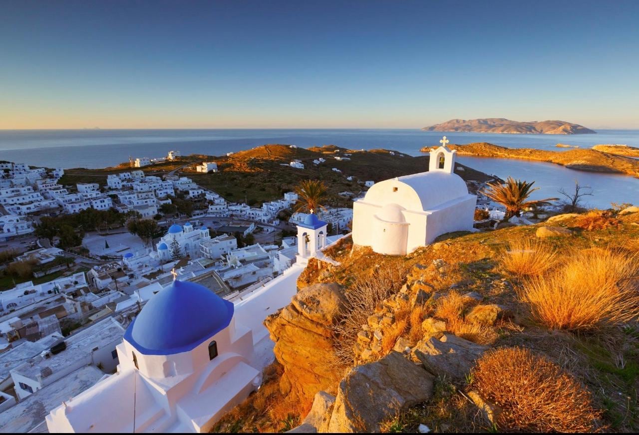 Golden-hour light over whitewashed Chora and its blue-domed church above the sea, Ios